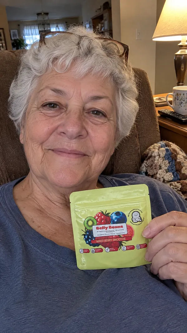 Woman in her seventies in her recliner, holding a pouch of Belly Beans