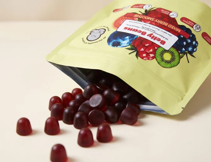 An open pouch of Belly Beans on a kitchen counter with the berry gummies spilling out