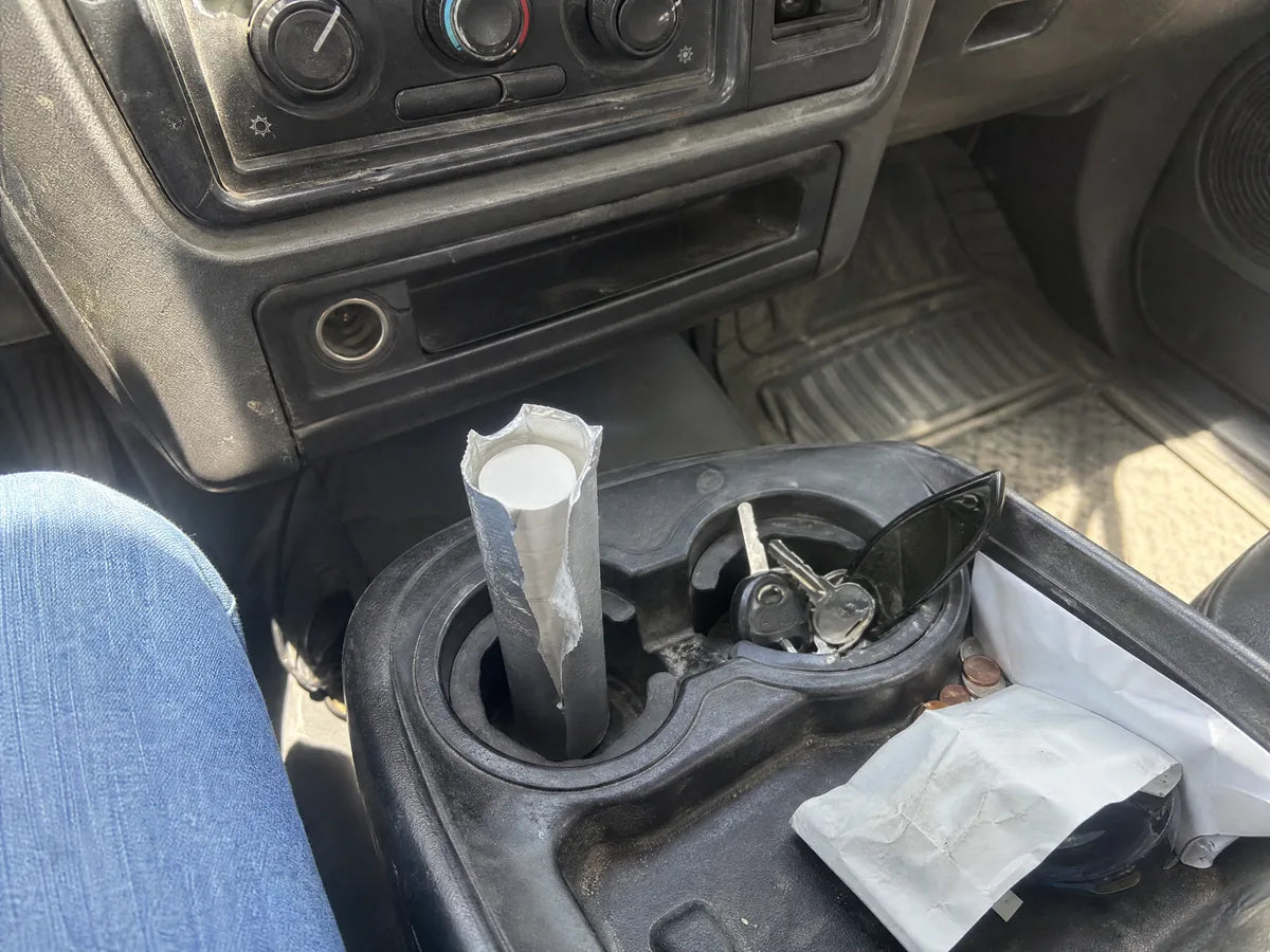 A half-used roll of antacid tablets in a pickup truck console cup holder