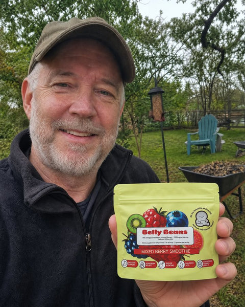 Customer holding a Belly Beans pouch in his backyard