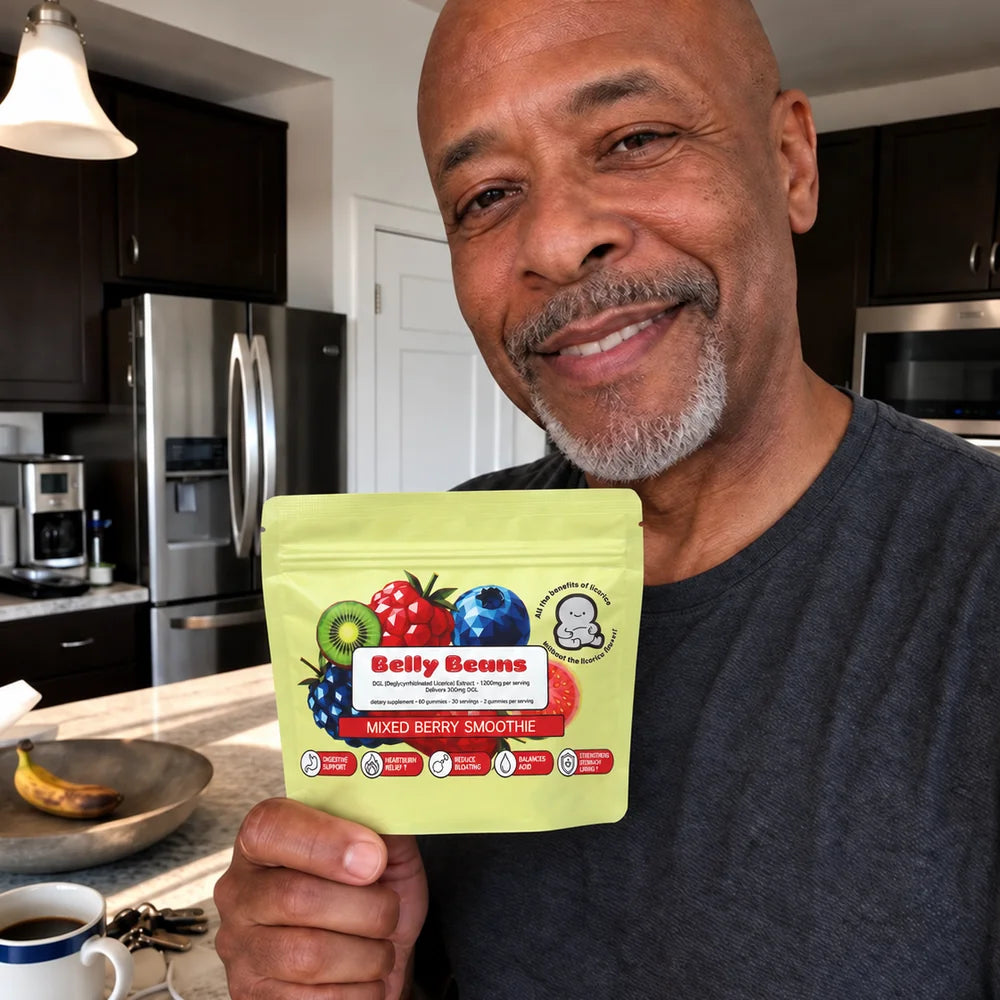 Man in his kitchen holding a pouch of Belly Beans Mixed Berry Smoothie DGL gummies