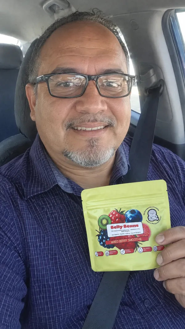 Man in his fifties in his car, holding a pouch of Belly Beans